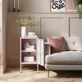 The Camden light pink metal storage locker open as a side table next to a sofa