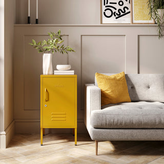 The Camden mustard yellow metal storage locker as a side table next to a sofa