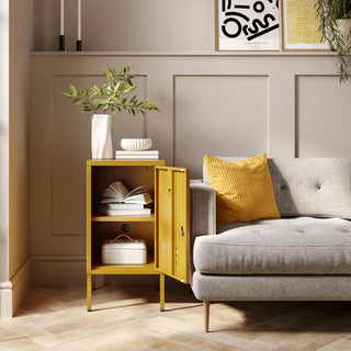 The Camden mustard yellow metal storage locker open as a side table next to a sofa