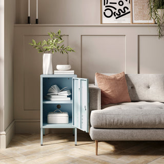 The Camden sky blue metal storage locker open as a side table next to a sofa