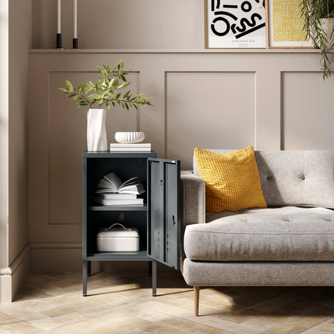 The Camden slate grey metal storage locker open as a side table next to a sofa