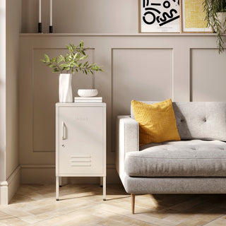 The Camden vanilla metal storage locker as a side table next to a sofa