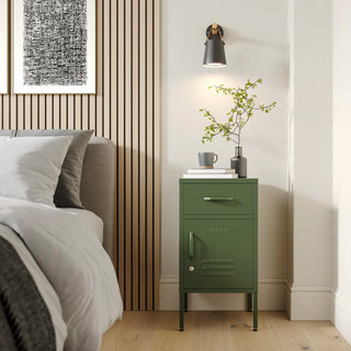 Metal side table locker in forest green with one drawer and one door, in a room next to a bed