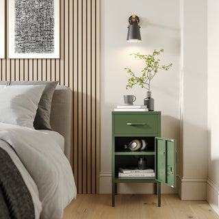 Metal side table locker in forest green with one drawer and one door open showing books, in a room next to a bed