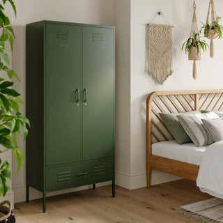 Metal, tall, double-door and single-drawer storage locker in forest green, in a bedroom