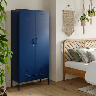 Metal, tall, double-door and single-drawer storage locker in navy blue, in a bedroom