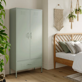 Metal, tall, double-door and single-drawer storage locker in sage green, in a bedroom