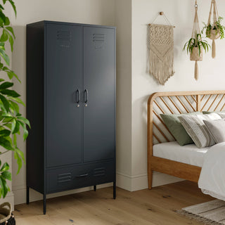 Metal, tall, double-door and single-drawer storage locker in slate grey, in a bedroom