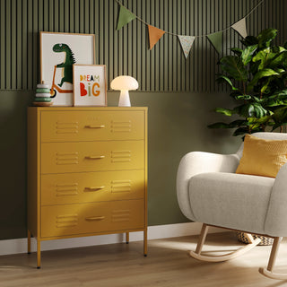 The Harrow mustard yellow metal drawers with 4 drawers, in a room next to a chair