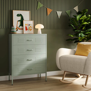 The Harrow sage green metal drawers with 4 drawers, in a room next to a chair