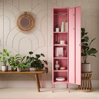 The Bexley single-door tall storage locker in flamingo pink, with the door open showing accessories and stationary