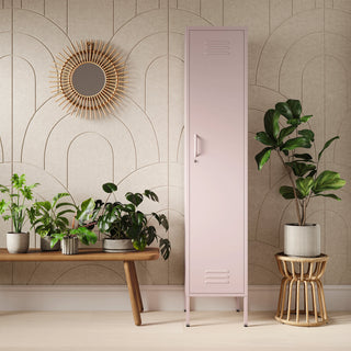 The Bexley single-door tall storage locker in light pink, next to some plants