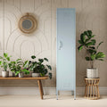 The Bexley single-door tall storage locker in sky blue, next to some plants