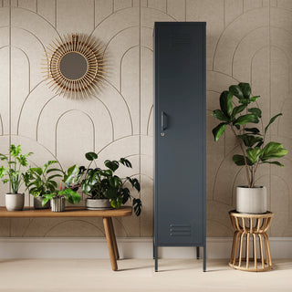 The Bexley single-door tall storage locker in slate grey, next to some plants